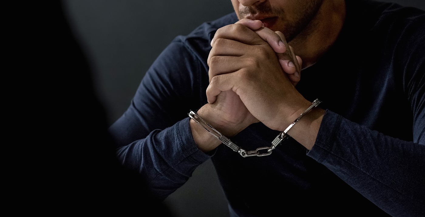 Distressed man being handcuffed by an officer, showcasing the severe consequences of driving under the influence.