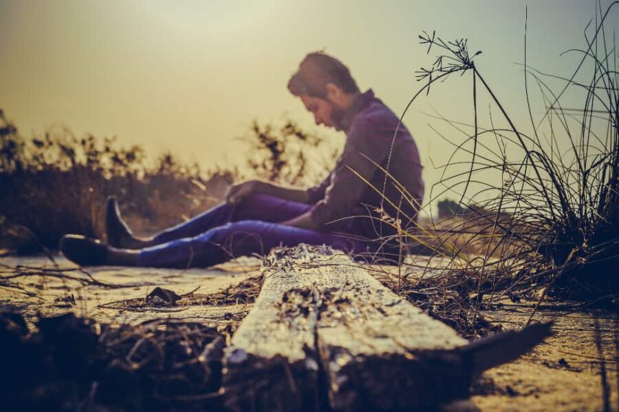 Despondent man on the beach, pondering the grip of the most addictive drugs on his life.