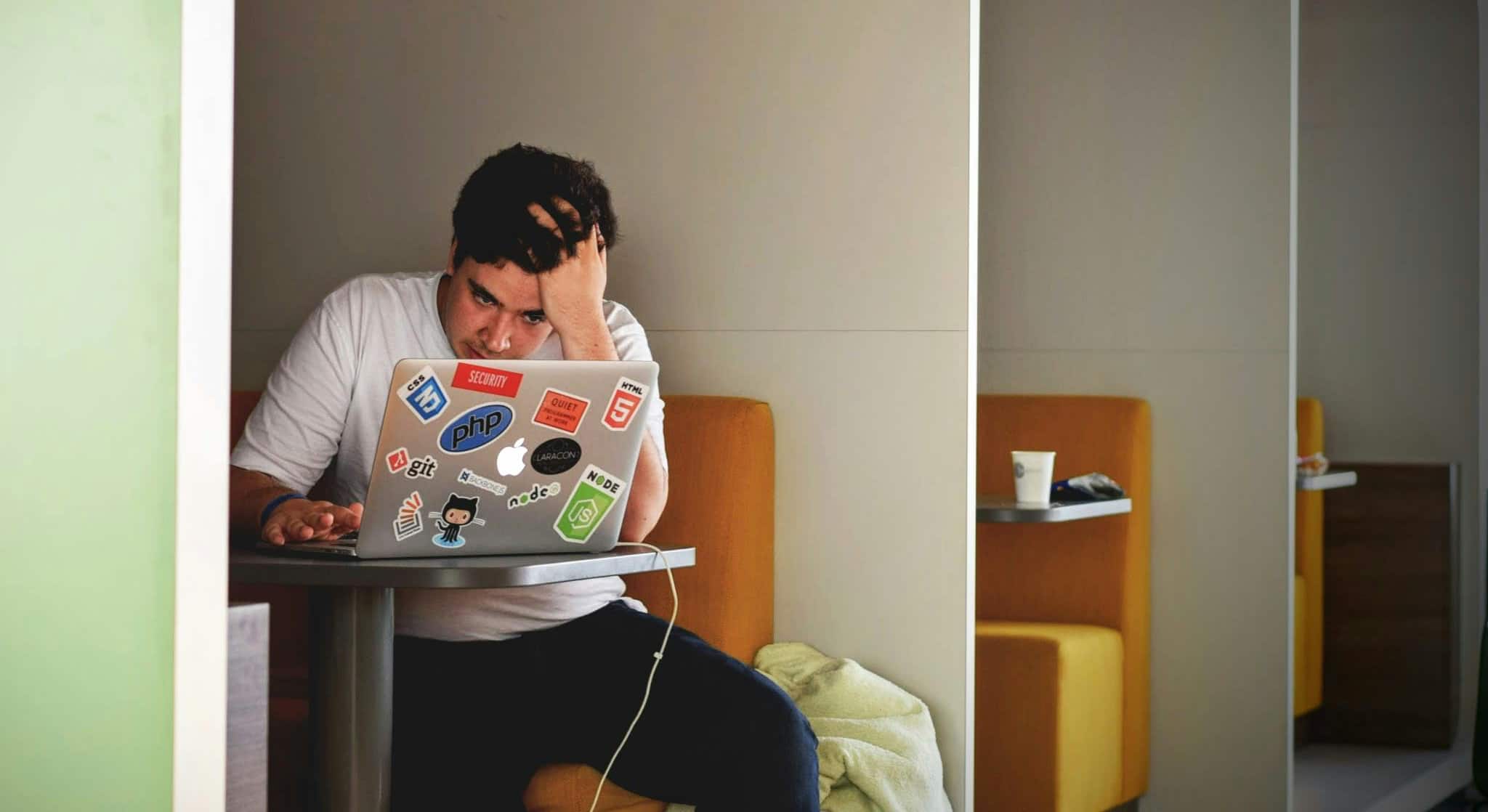 Anxious man with hand in hair, researching benzo detox options on his computer.