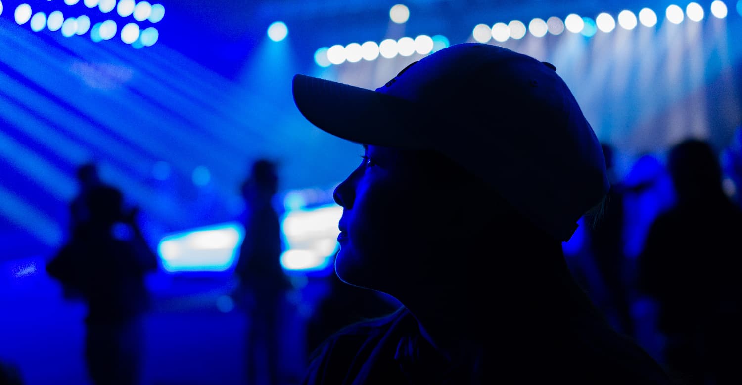 Young woman looking pensive with a rave in the background, illustrating the dangers of Molly.