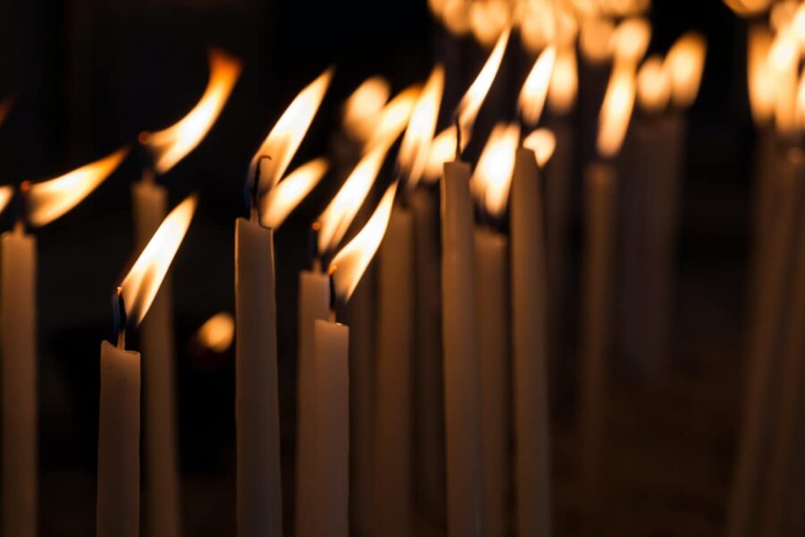 Numerous candles standing steadfast against a blowing wind, metaphorically illustrating the enduring strength and resilience required in the journey of inpatient detox rehab, despite the challenges faced