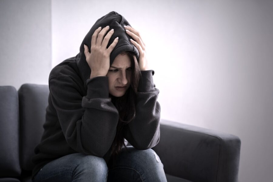 Woman in a hoodie experiencing severe alcohol withdrawal symptoms