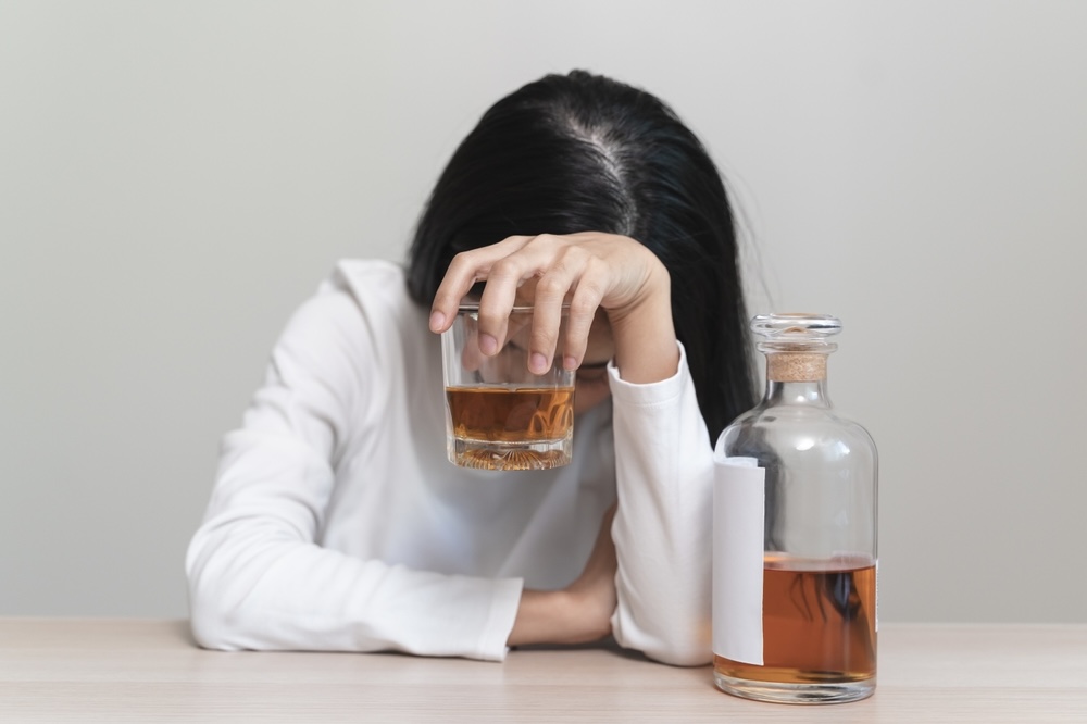 Woman holding a glass of alcohol struggling with substance abuse