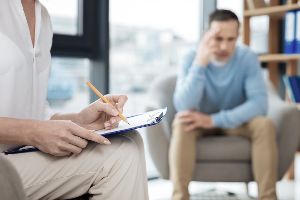 Man speaking to an addiction specialist before going to alcohol detox program