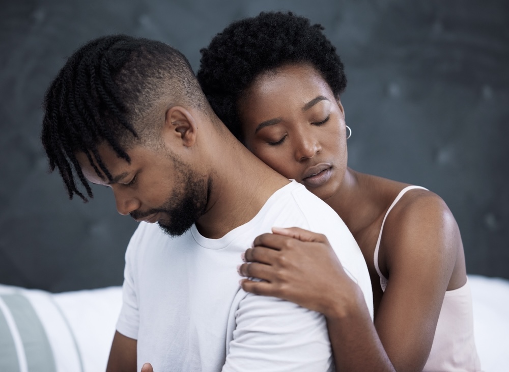 Female hugging her partner from the back after telling him to seek drug detox treatment