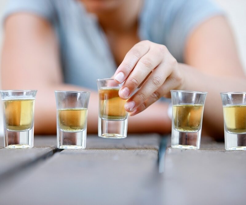 Man drinking several shots of tequila during the holiday season